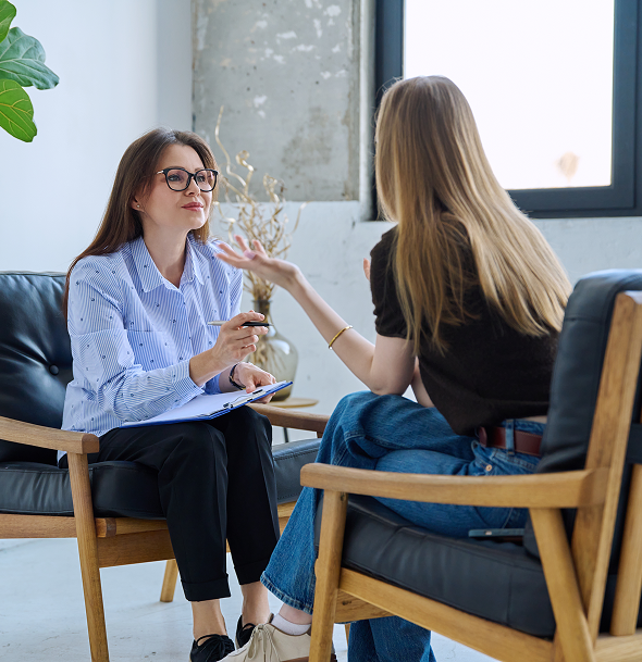 Two women engaged in a serious conversation in a cozy office.