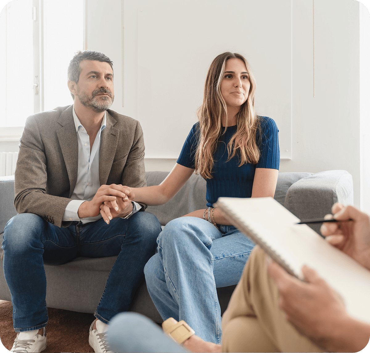 Couple in therapy session holding hands.
