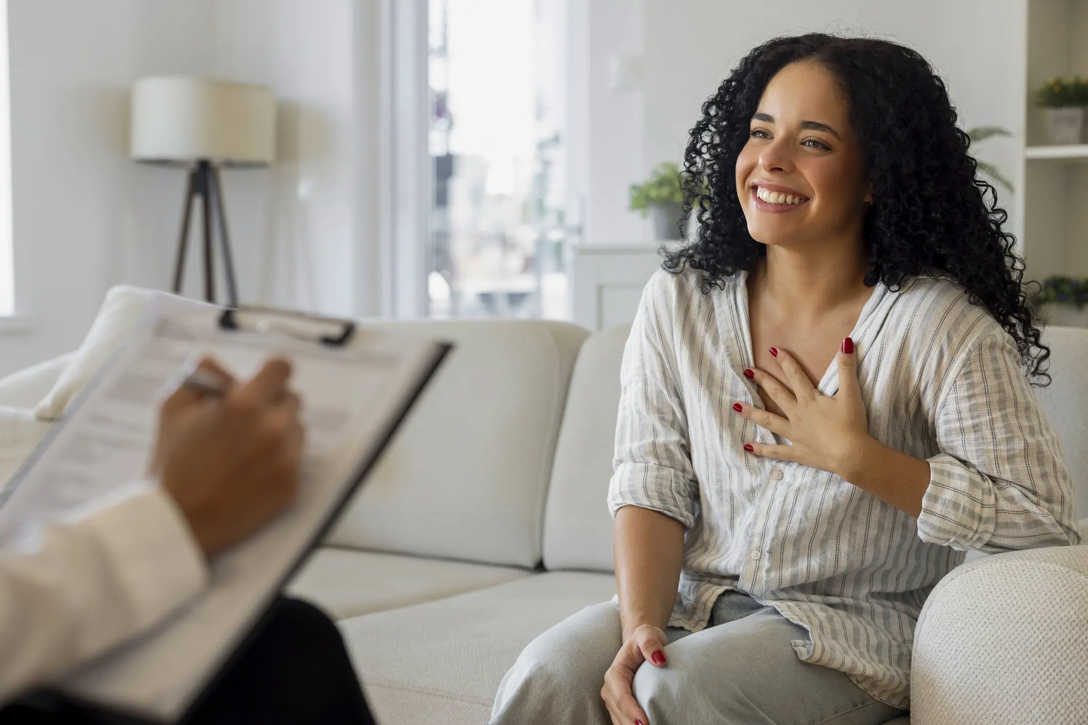 A woman smiling warmly during a therapy session.