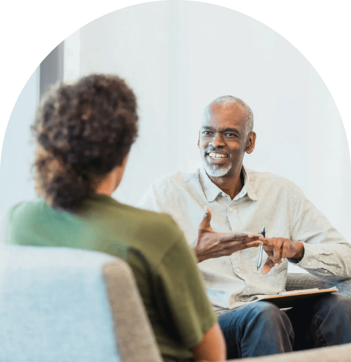 A therapist engaging in a discussion with a client in a bright office.
