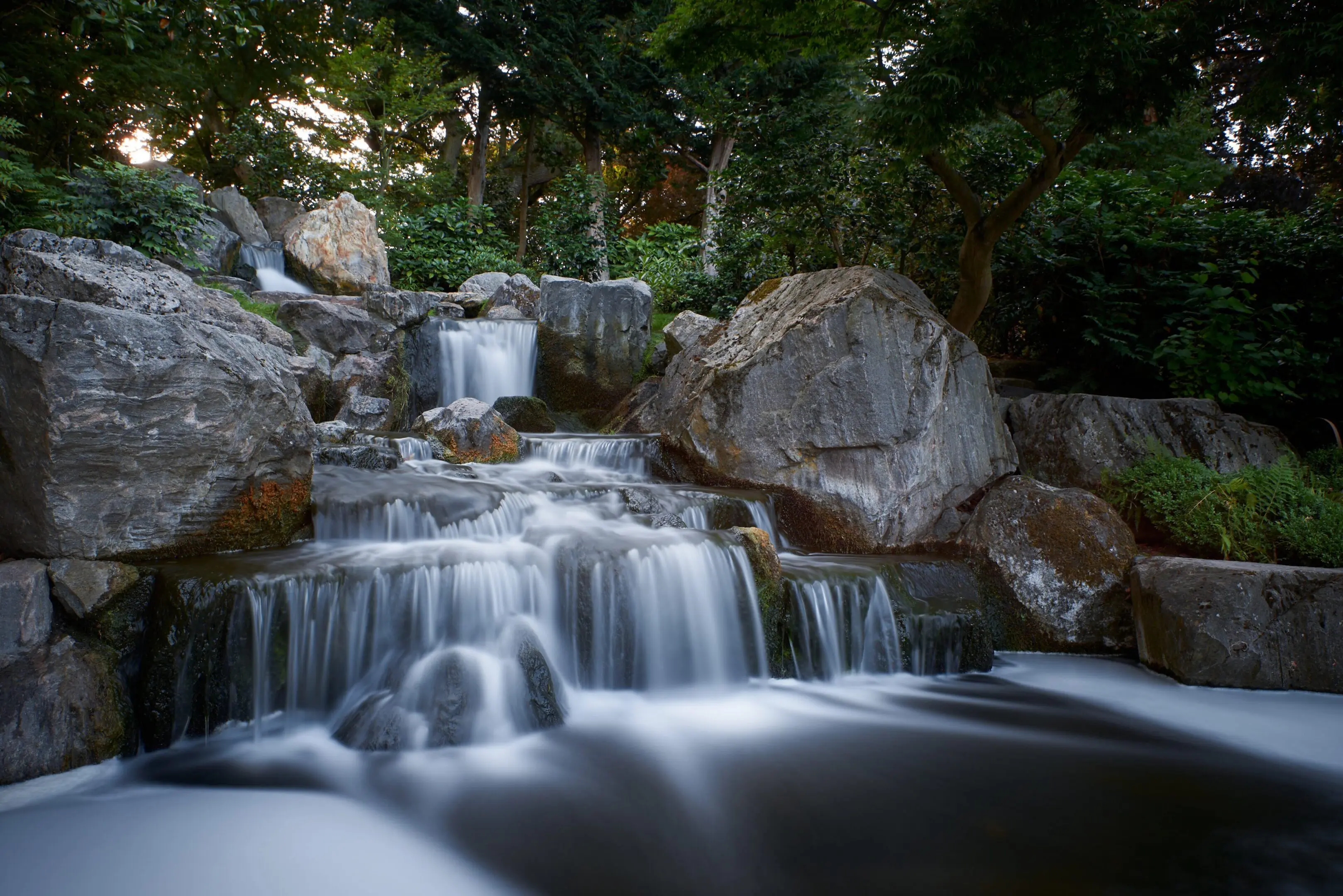 Tiered waterfall flowing over rocks in forest